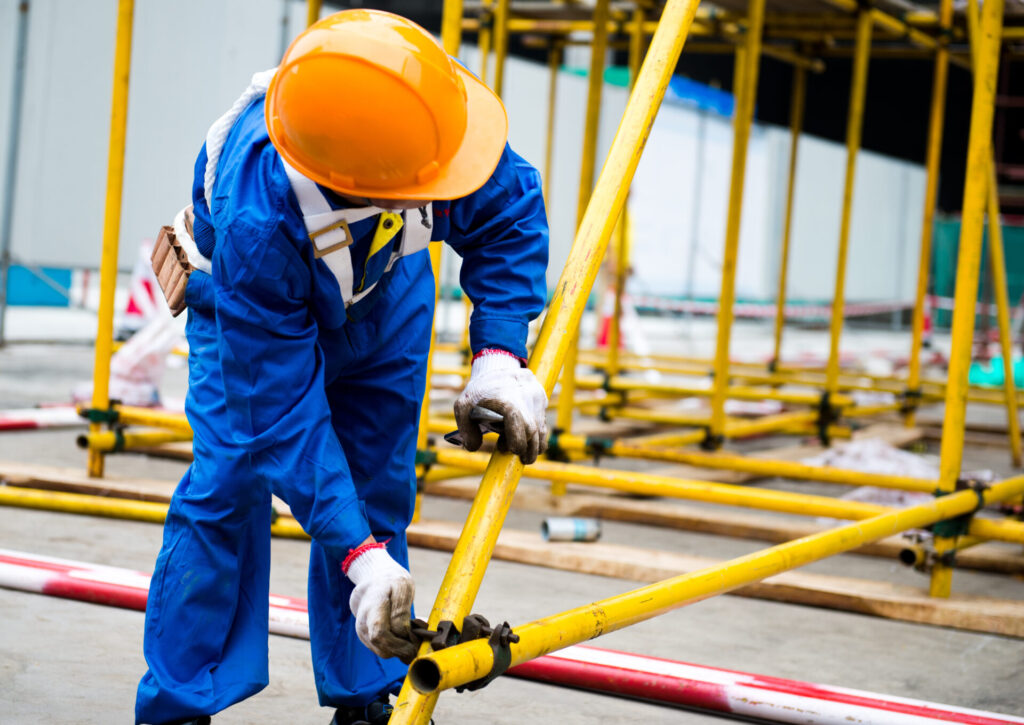 Worker in Blue Overalls Inspecting Equipment