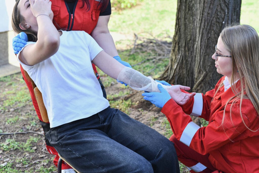First aiders treating an arm wound outdoors