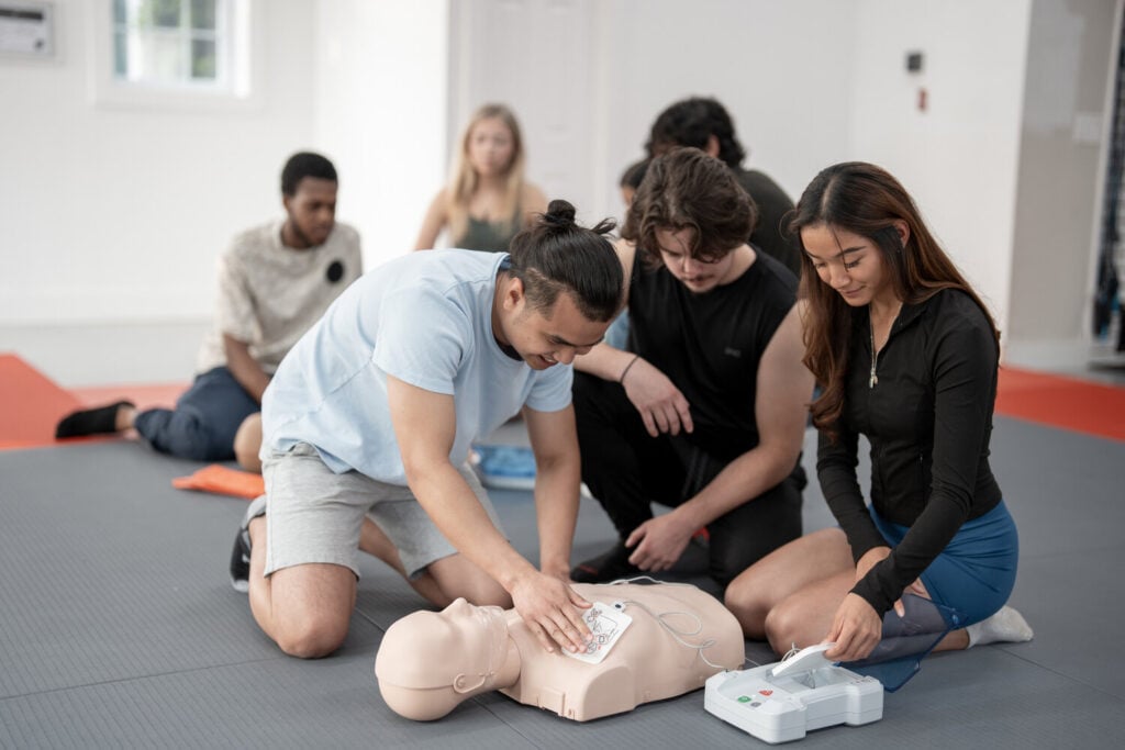 Students practising AED pad placement in first aid training